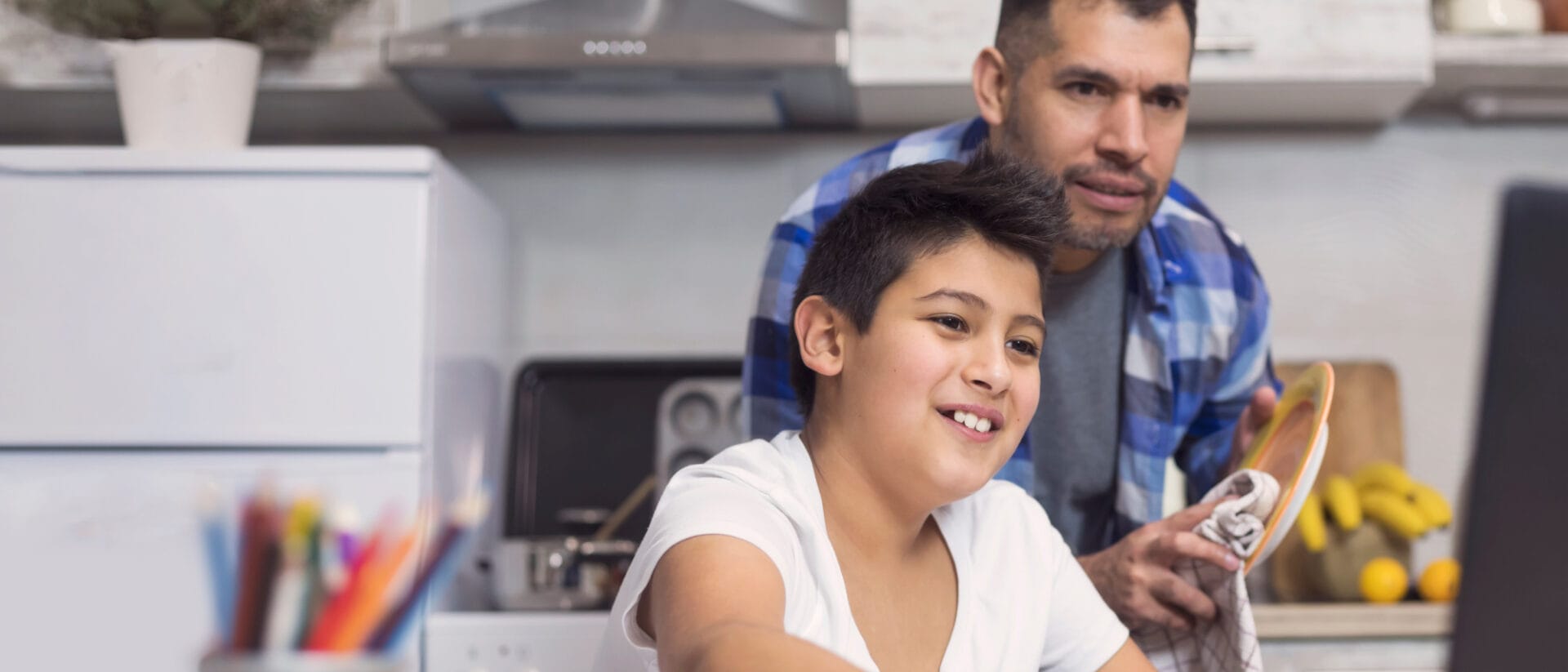Father and son attending to an online class